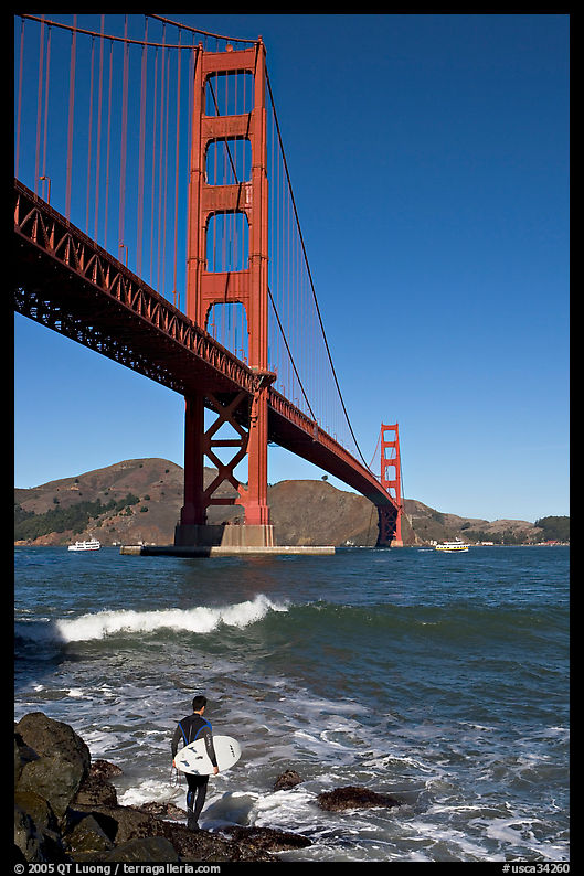 Surfer and wave below the Golden Gate Bridge. San Francisco, California, USA