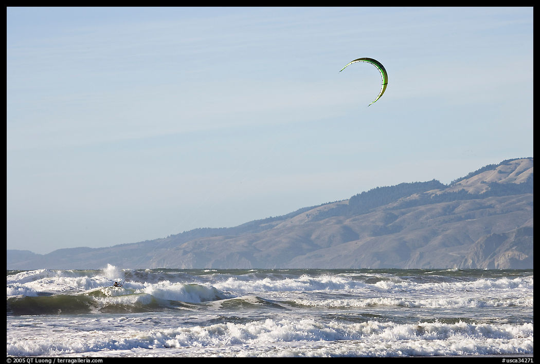 Kite surfer in Pacific Ocean waves, afternoon. San Francisco, California, USA
