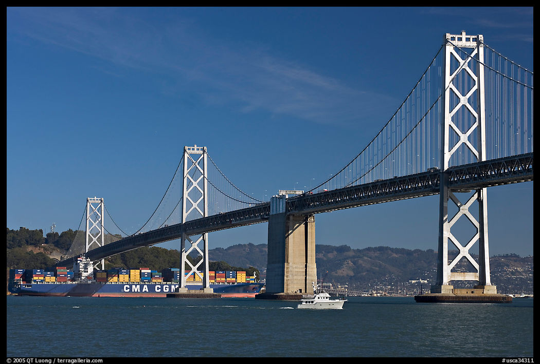 Cargo ship passing below the Bay Bridge. San Francisco, California, USA