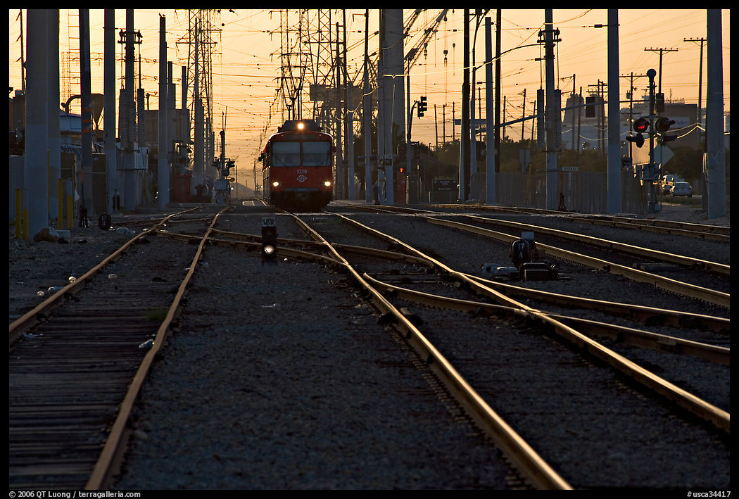 Railroad tracks, train, and power lines, sunrise. San Diego, California, USA