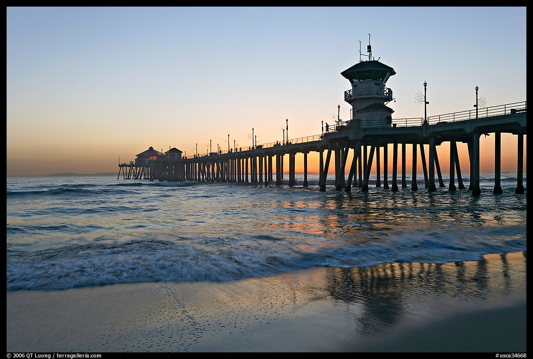Huntington Pier reflected in wet sand at sunset. Huntington Beach, Orange County, California, USA