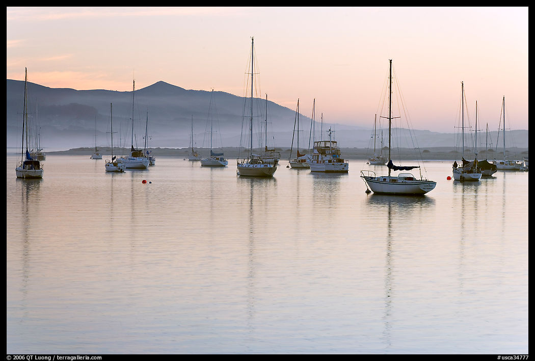 Yachts reflected in calm  Morro Bay harbor, sunset. Morro Bay, USA