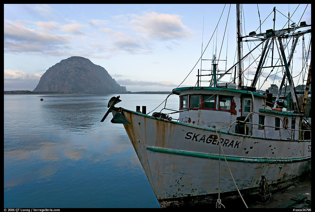 Baat with rusted hull and Morro Rock. Morro Bay, USA