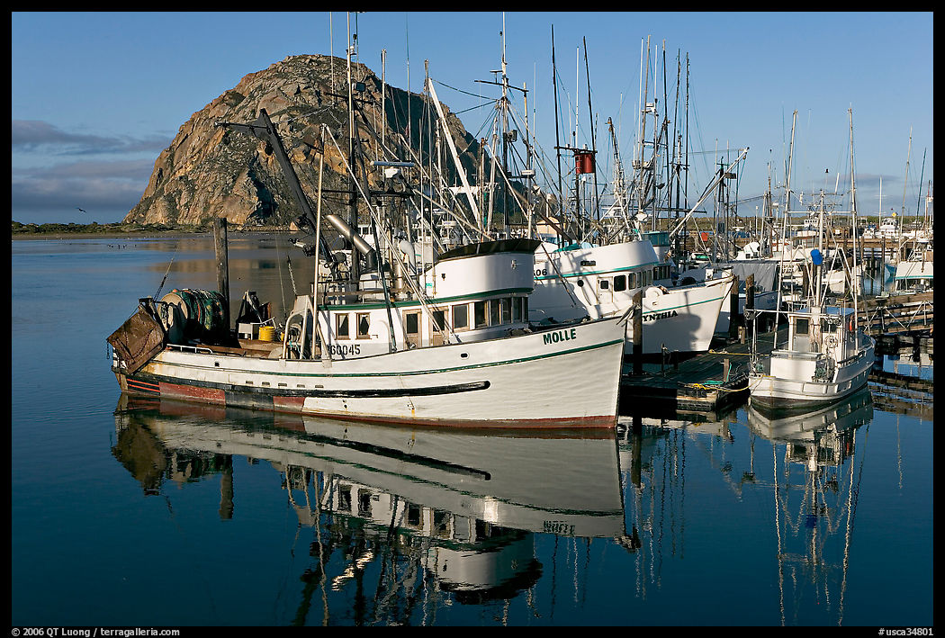 Fishing boats with reflexions and Morro Rock, early morning. Morro Bay, USA