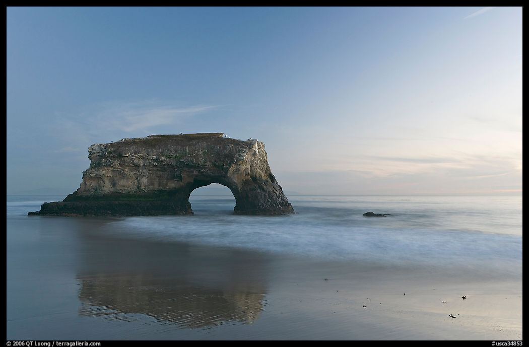 Sea arch and reflection, Natural Bridges State Park, dusk. Santa Cruz, California, USA
