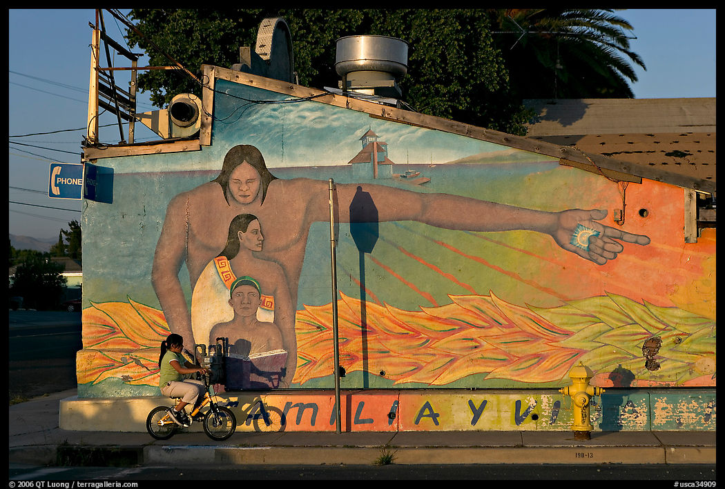 Hispanic girl on bicycle and mural, Alviso. San Jose, California, USA