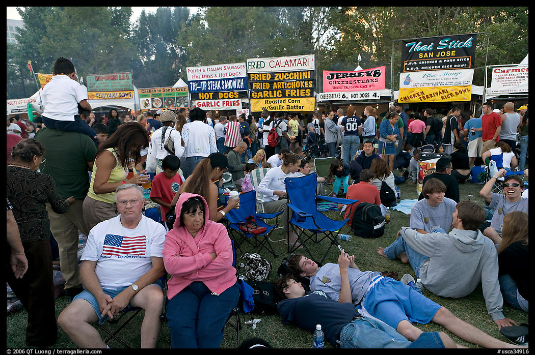 Crowd sitting on the grass in Guadalupe River Park, Independence Day. San Jose, California, USA