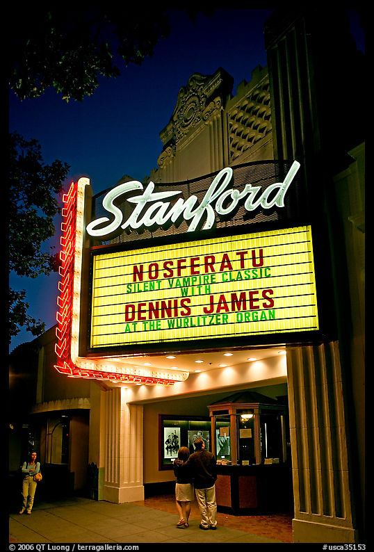 Couple standing in front of Stanford Theatre at night. Palo Alto, SF Bay area, California, USA
