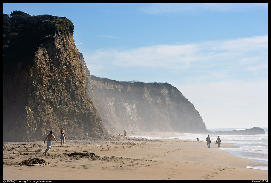 People strolling and playing below cliffs, Scott Creek Beach. SF Bay area, California, USA