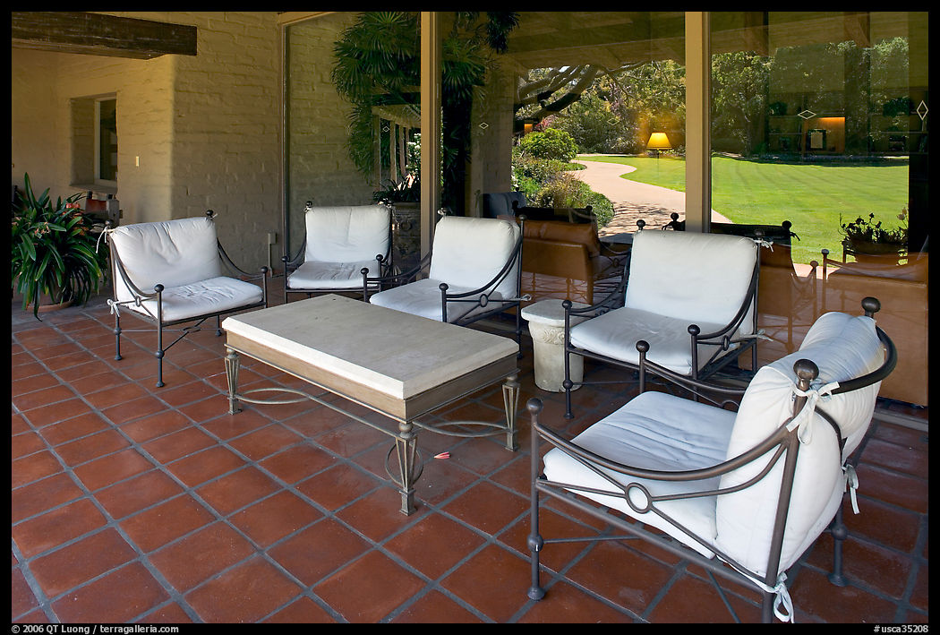Chairs and coffee table on porch, Sunset gardens reflected. Menlo Park, SF Bay area, California, USA