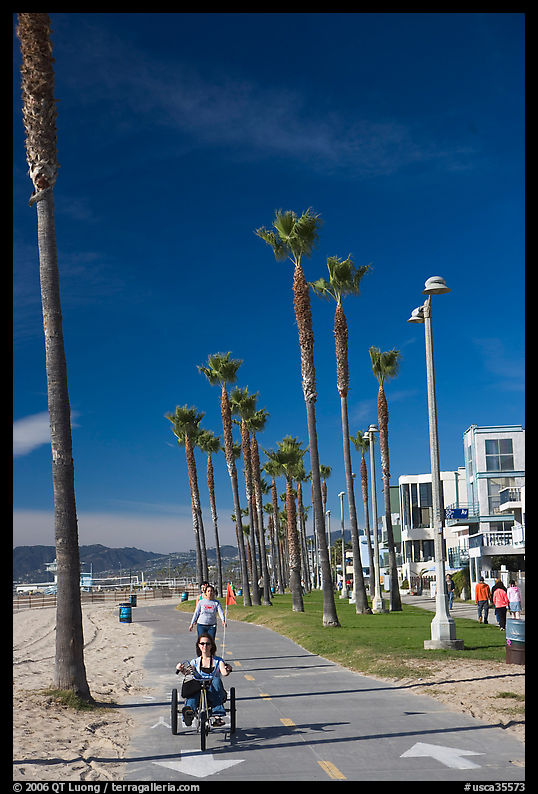 Woman riding a tricycle on the beach promenade. Venice, Los Angeles, California, USA