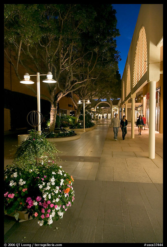 Couple walking by stores and flowers, Stanford Shopping Center. Stanford University, SF Bay area, California, USA
