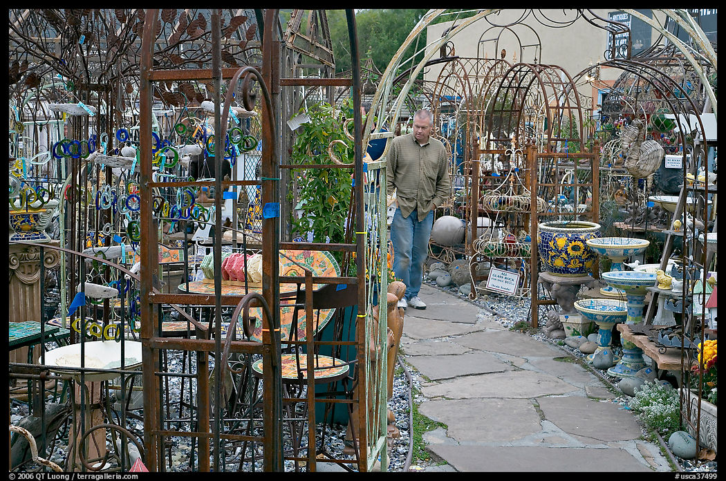 Man browsing in colorful outdoor antique display. Half Moon Bay, California, USA