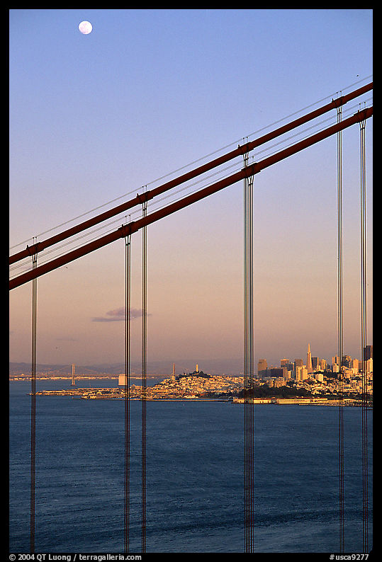The city seen through the cables of the Golden Gate bridge, sunset. San Francisco, California, USA