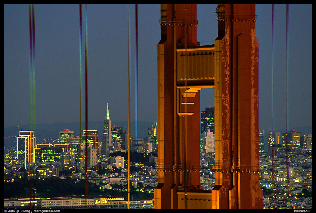 The city seen through the cables and pilars of the Golden Gate bridge, night. San Francisco, California, USA
