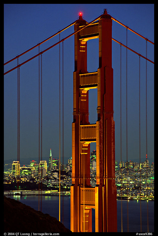 The city seen through the cables and pilars of the Golden Gate bridge, night. San Francisco, California, USA