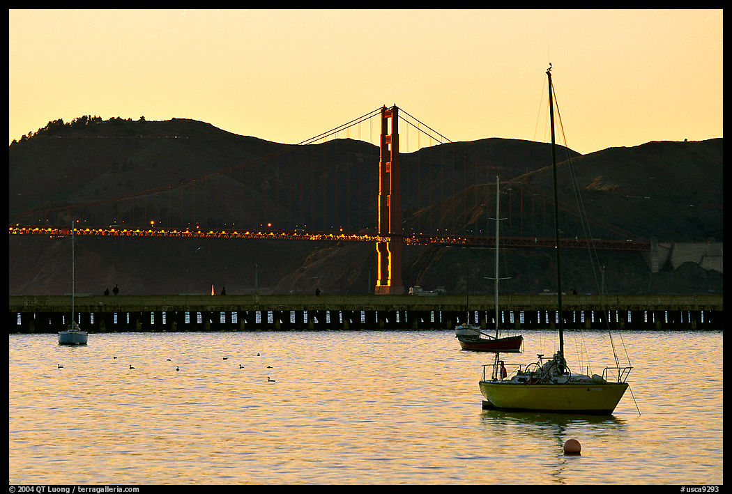Sailboat in the Marina, with Golden Gate Bridge at sunset in the background. San Francisco, California, USA