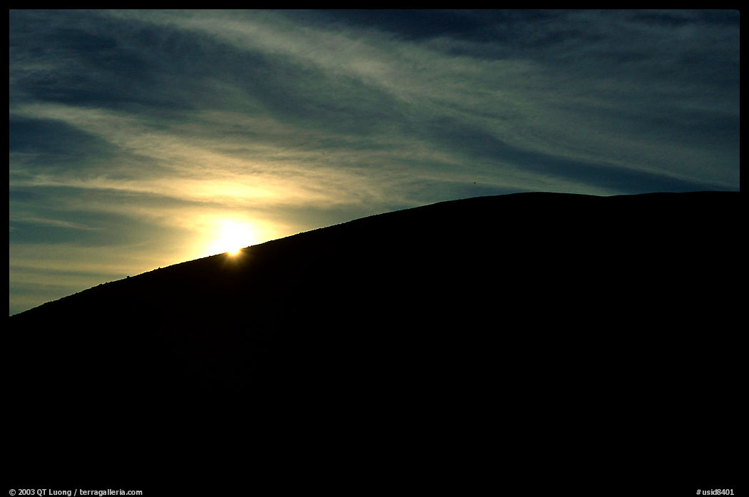 Sun at the rim of a cinder cone, sunrise, Craters of the Moon National Monument. Idaho, USA