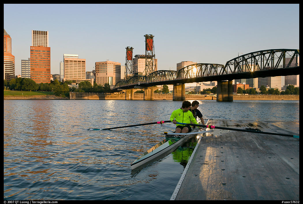 Rowers on double-oar shell lauching from deck in front of skyline. Portland, Oregon, USA