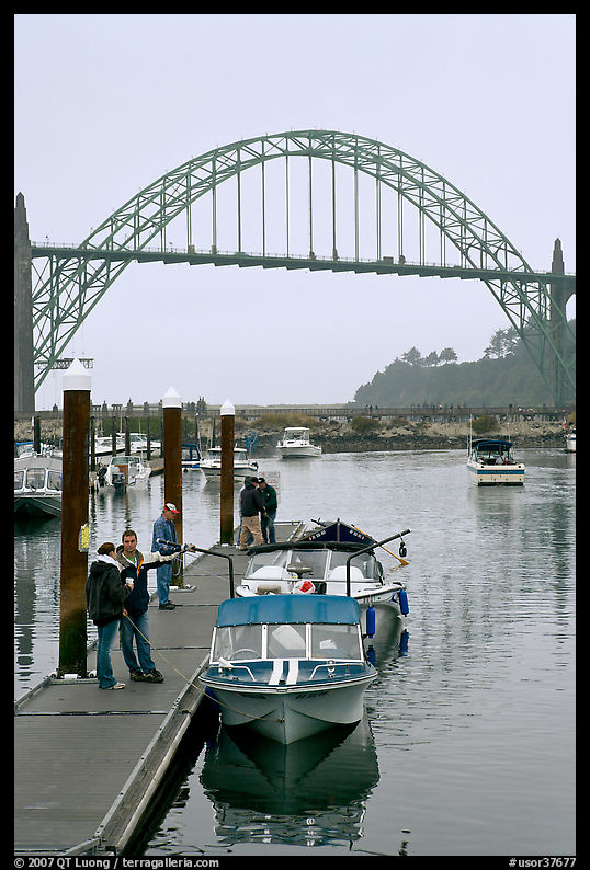 Couple holding small boat at boat lauch ramp. Newport, Oregon, USA