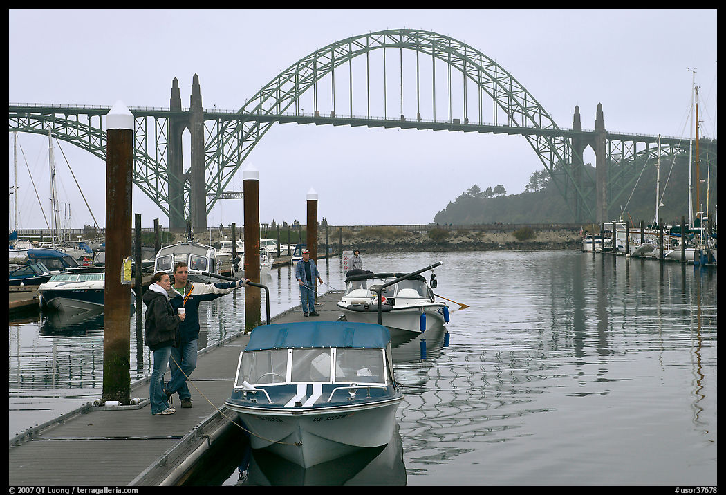 Couple holds  small boat on pier, Newport Marina. Newport, Oregon, USA