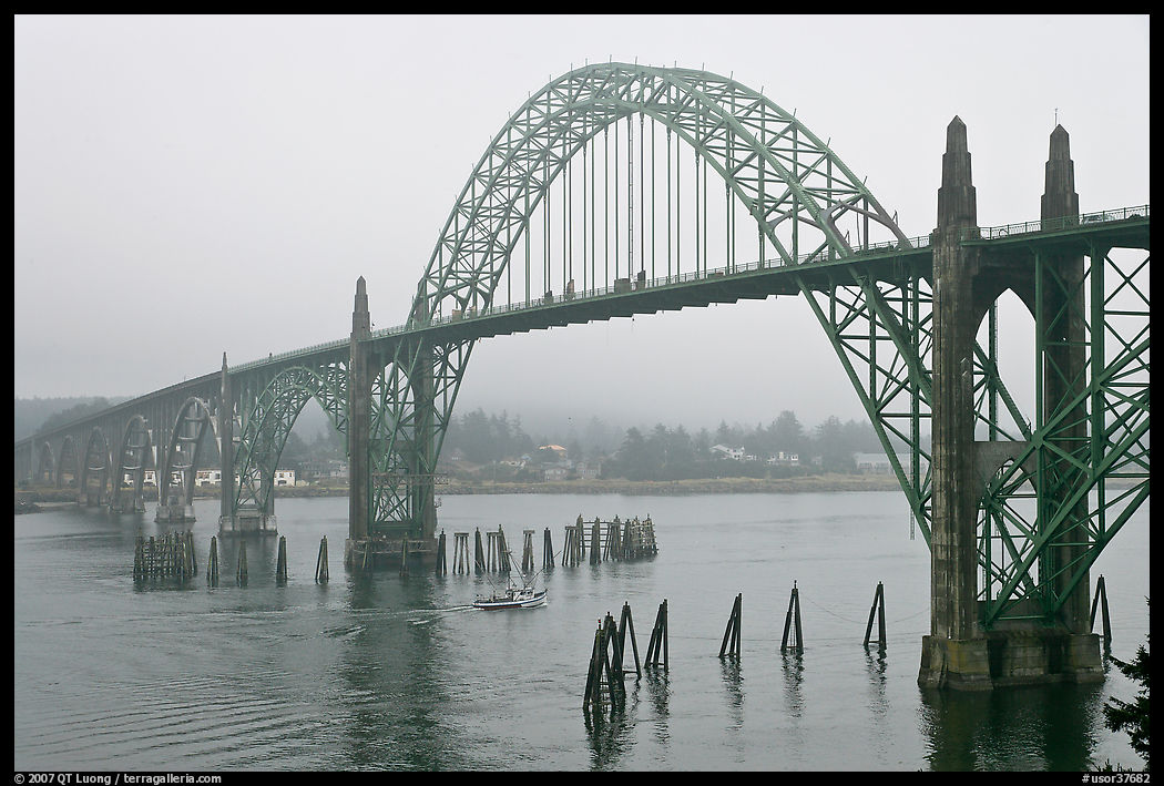 Small boat exiting harbor under Yaquina Bay Bridge. Newport, Oregon, USA
