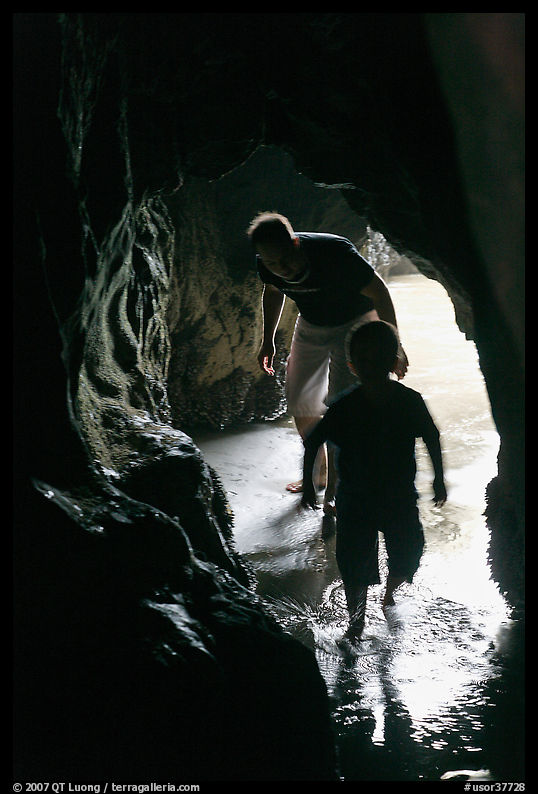 Boy and man exploring sea cave. Bandon, Oregon, USA