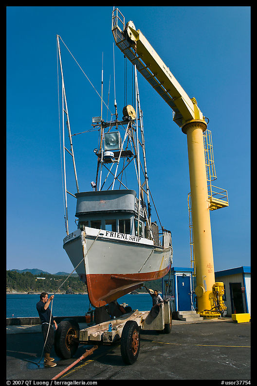 Fishing boat lifted from water by huge hoist, Port Orford. Oregon, USA