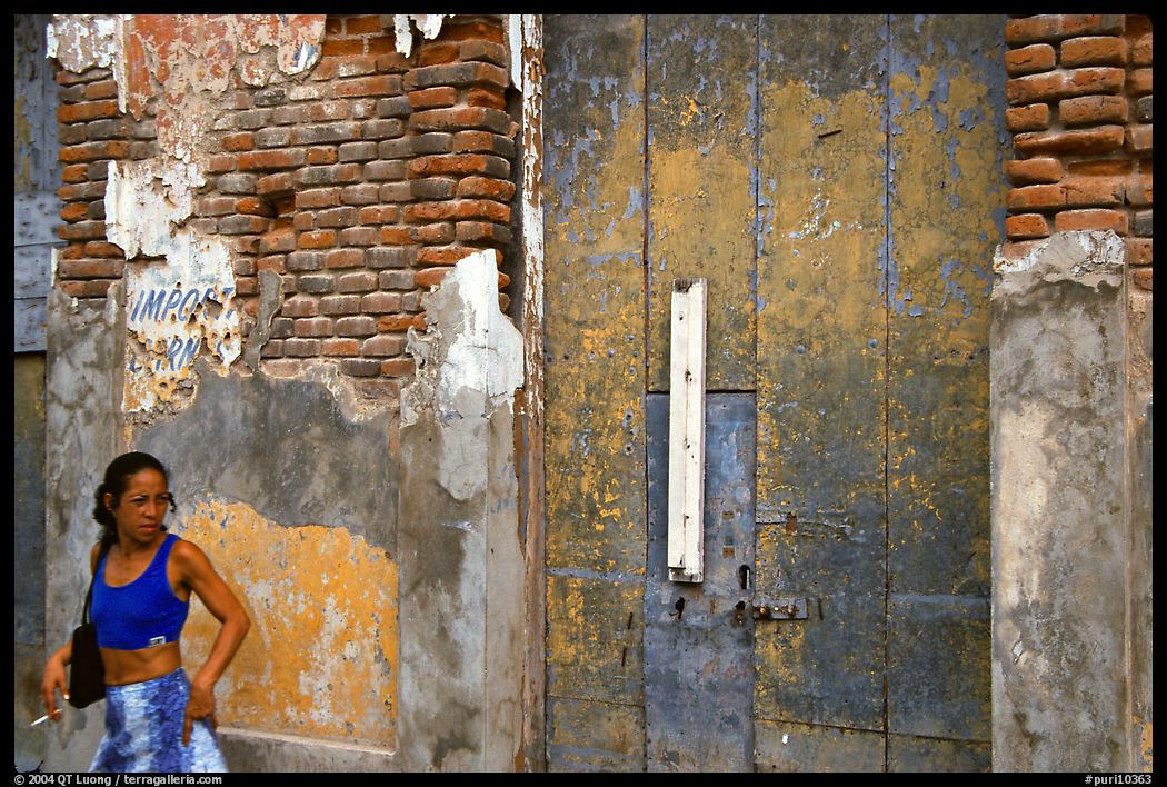 Woman in front of a decaying brick wall, Ponce. Puerto Rico