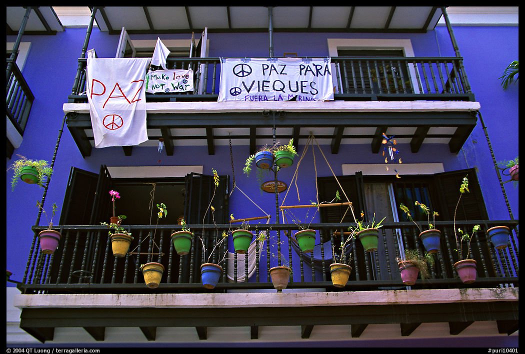 Facade of house painted in blue with pots, balconies and anti-war signs. San Juan, Puerto Rico
