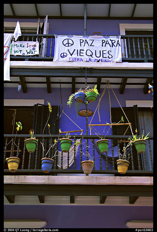 Facade of house painted in blue with plant pots and balconies. San Juan, Puerto Rico