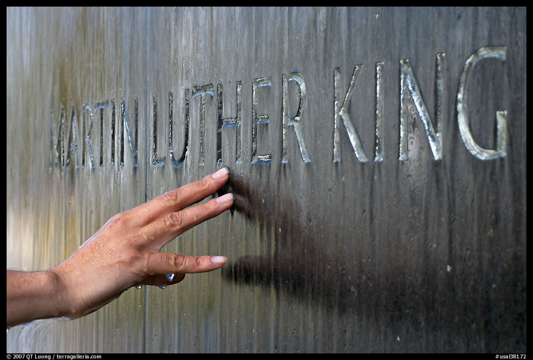 Hand touching the letters Martin Luther King in flowing water. Montgomery, Alabama, USA