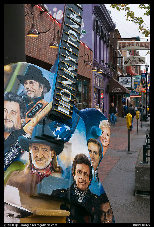 Guitar-shaped sign with images of famous singers on Broadway sidewalk. Nashville, Tennessee, USA