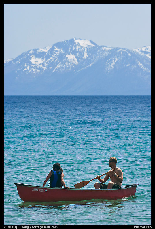 Man and woman in canoe with snowy mountains in the background, Lake Tahoe, Nevada. USA