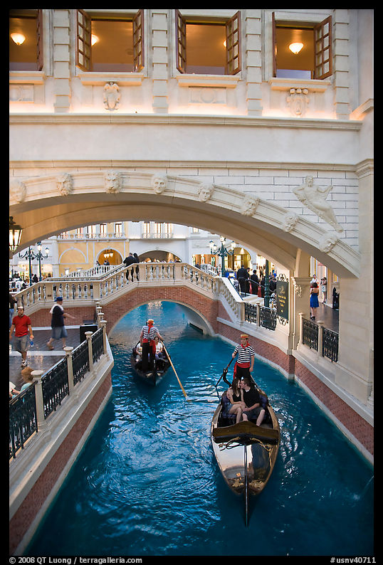 Couple kissing in gondola below bridge, Venetian casino. Las Vegas, Nevada, USA