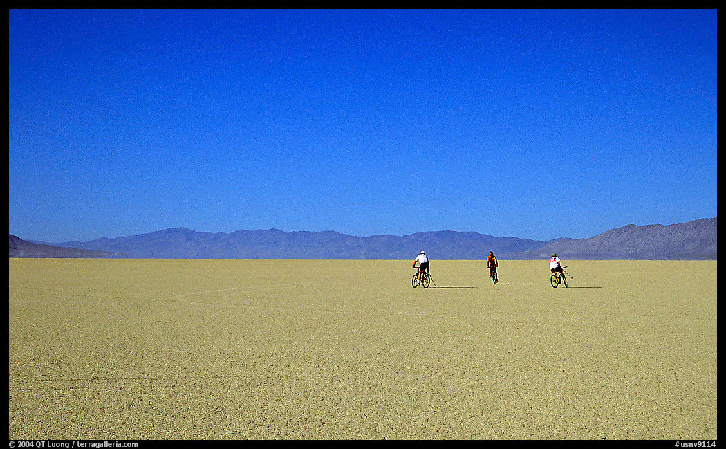 Three bicyclists on the desert Playa. Black Rock Desert, Nevada, USA