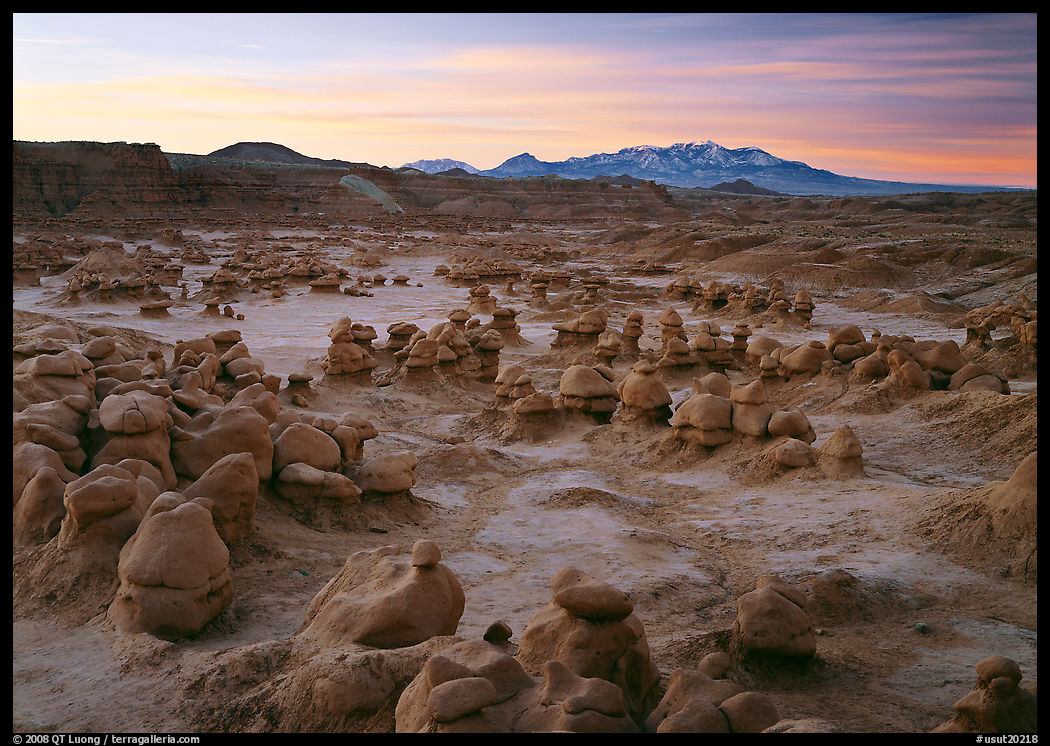 Goblins and snowy mountains at sunrise, Goblin State Park. Utah, USA