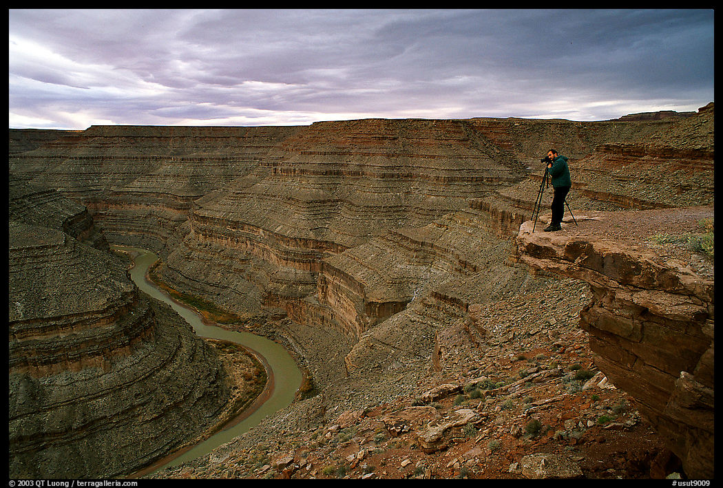 Photographer on overhang above the San Juan River, Goosenecks of the San Juan State Park. Utah, USA