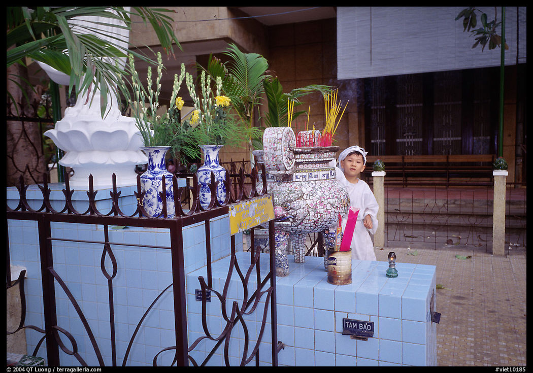 Kid in mourning dress at an outdoor altar, Xa Loi pagoda. Ho Chi Minh City, Vietnam