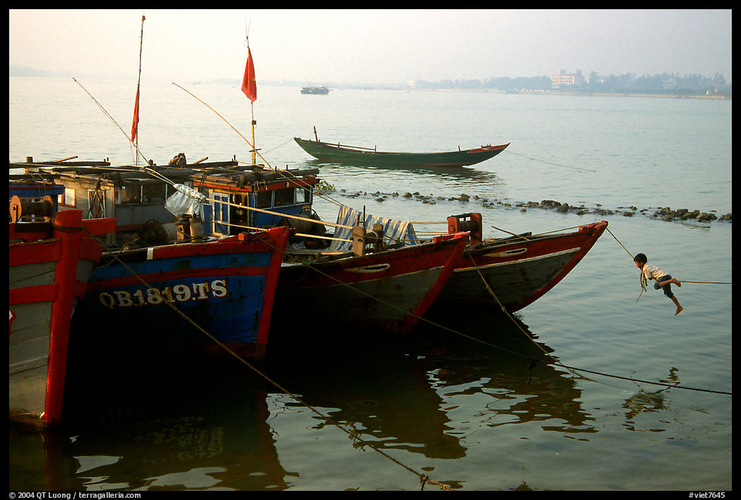 Children climbing aboad Fishing boat, Dong Hoi. Vietnam