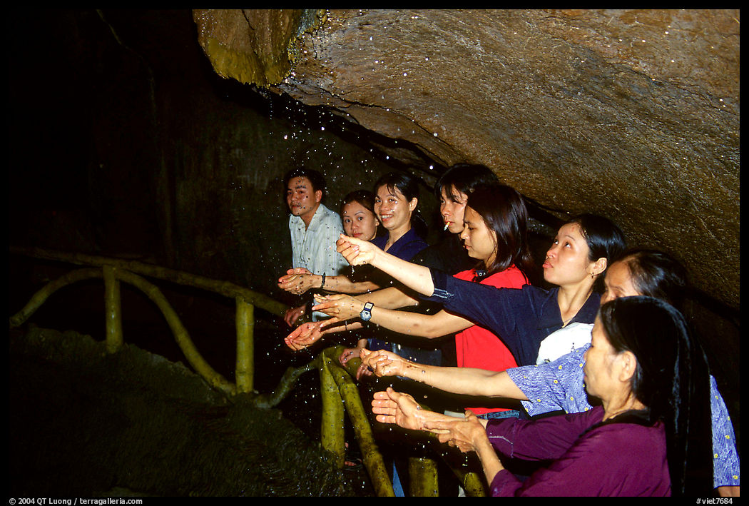 Women catch the water seeping from Tan Thanh Cave, said to have mirculous properties. Lang Son, Northest Vietnam