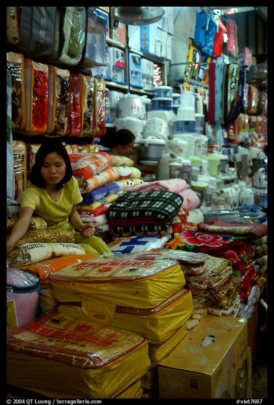 Vendor sitting amongst Abondance of cheap goods imported from nearby China at the Dong Kinh Market. Lang Son, Northest Vietnam