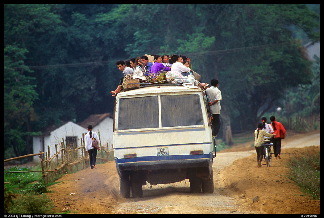Passengers sitting on top of an overloaded bus. Northest Vietnam