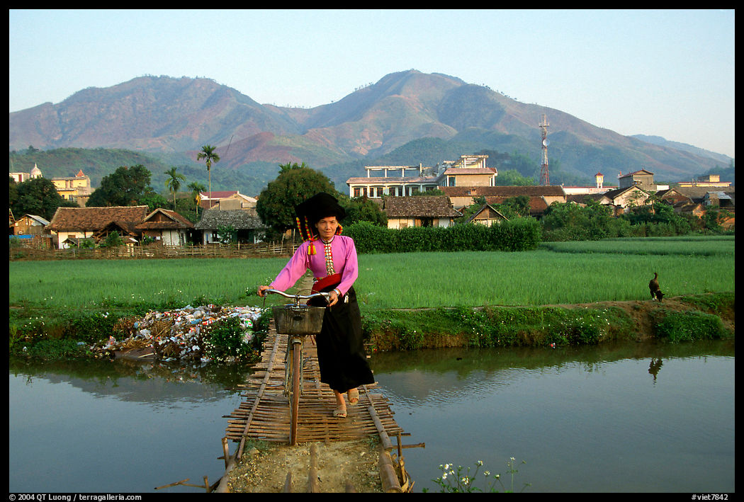 Thai woman pushing her bicycle across a bridge, Tuan Giao. Northwest Vietnam
