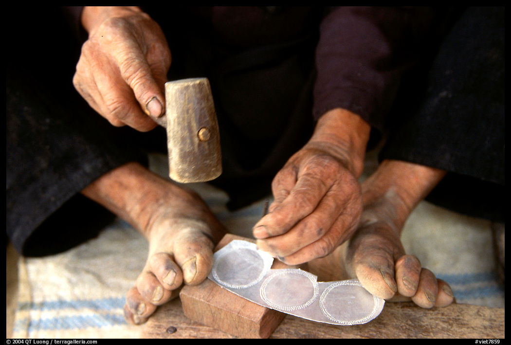 Hands and feet of a Black Dzao man making decorative coins, between Tam Duong and Sapa. Northwest Vietnam