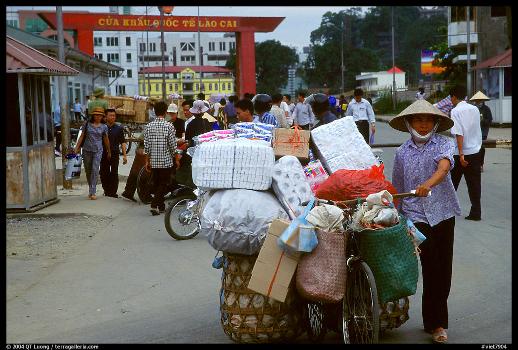 Woman pushing a bicycle loaded with cheap goods at the Lao Cai border crossing. Vietnam