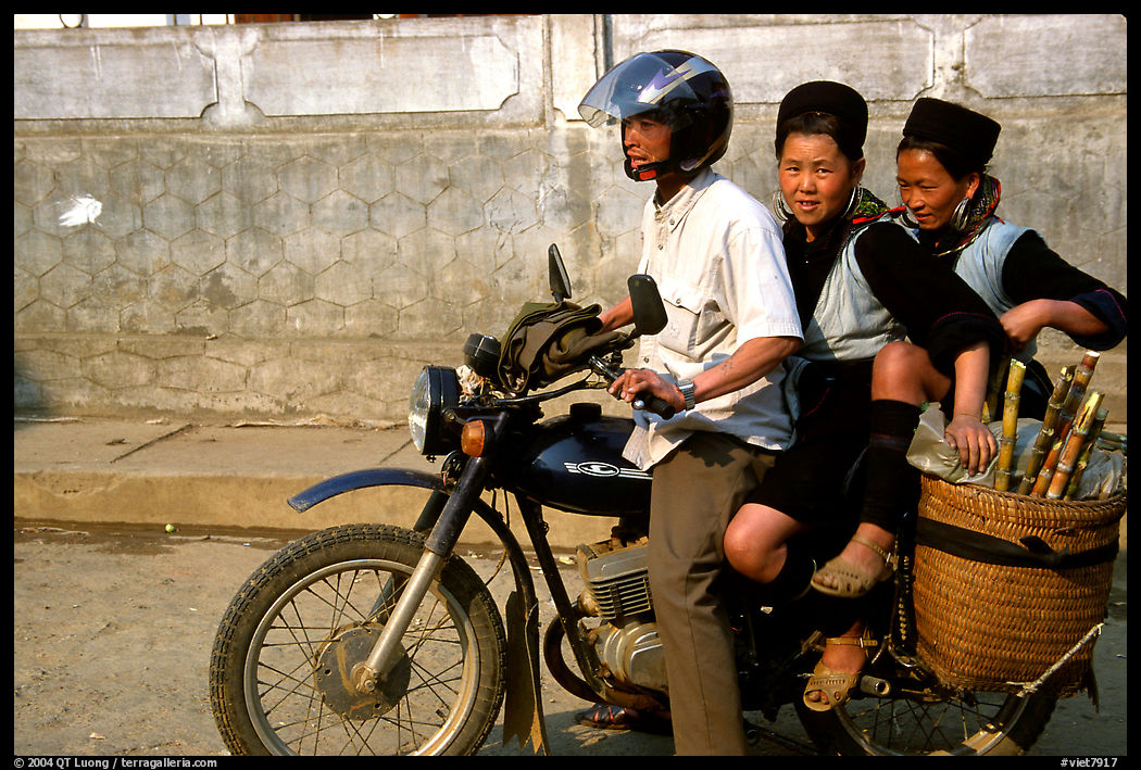 Black Hmong Women riding at the back of a Russian motorbike. Sapa, Vietnam