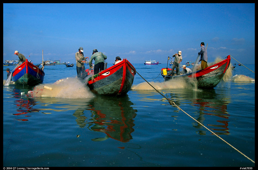 Fishermen get their nets out of their small fishing boats. Vung Tau, Vietnam