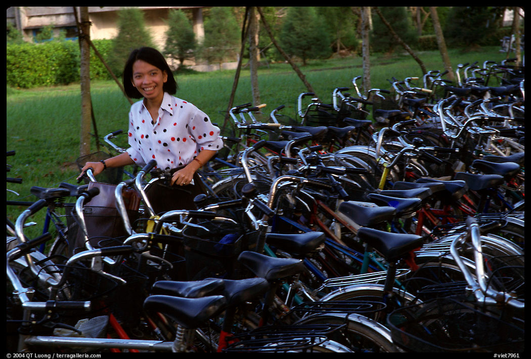 Woman retrieving her bicycle from a bicyle parking area. Mekong Delta region, Vietnam