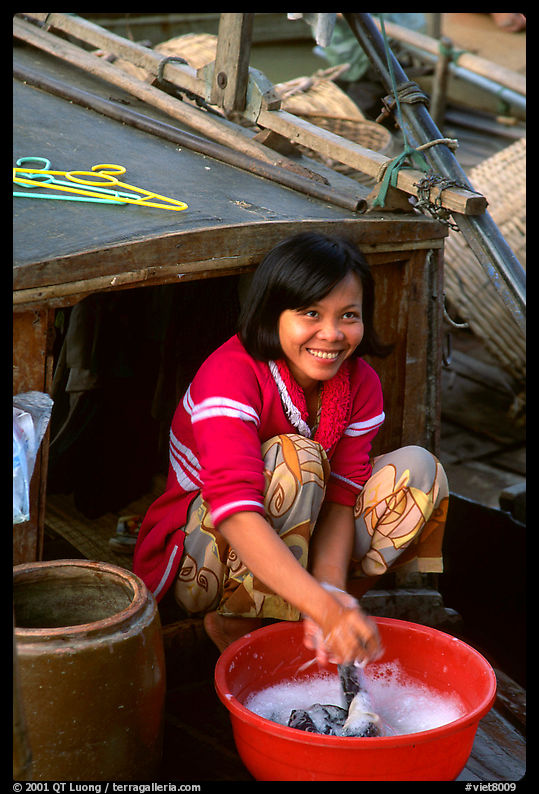 Woman doing laundry on live-aboard boat, the cheapest and most convenient housing in the Delta, near Can Tho. Vietnam